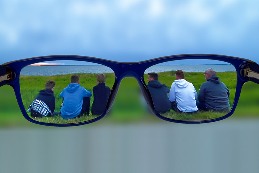 sitzende Menschen von hinten, gesehen durch eine Brille