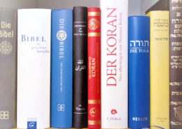 Bibel, Koran und Tora etc. auf einem Bücherbrett nebeneinander